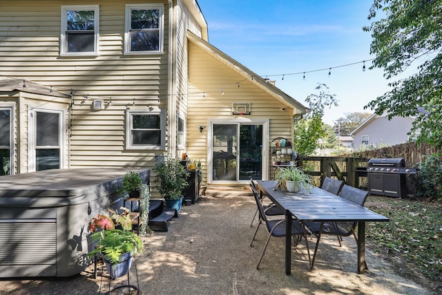 back of property featuring a patio and a hot tub