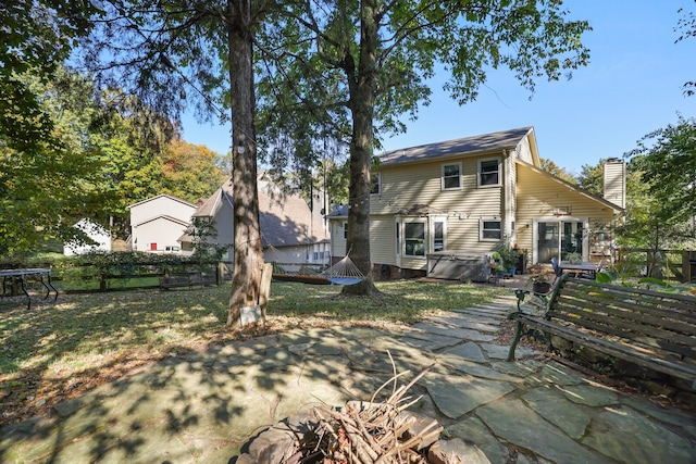 rear view of house featuring a patio and a lawn