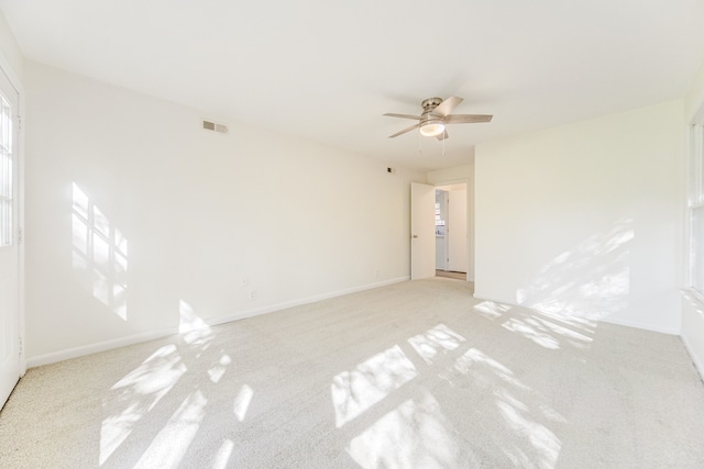 spare room featuring light carpet and ceiling fan