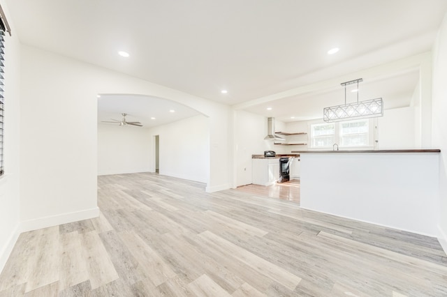 unfurnished living room with light hardwood / wood-style floors and ceiling fan