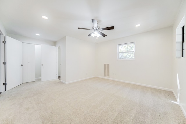 unfurnished room with light colored carpet and ceiling fan