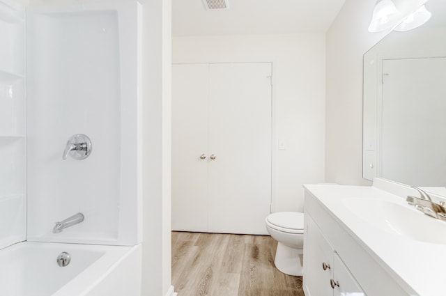 full bathroom with vanity, toilet, hardwood / wood-style flooring, and washtub / shower combination