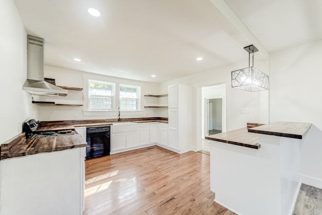 kitchen featuring black dishwasher, extractor fan, white cabinetry, pendant lighting, and light hardwood / wood-style floors