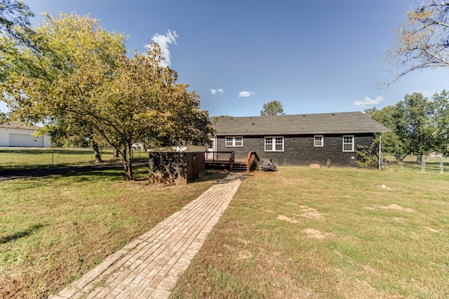 back of house with a wooden deck and a lawn