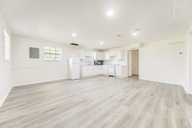 unfurnished living room with sink, electric panel, and light hardwood / wood-style flooring