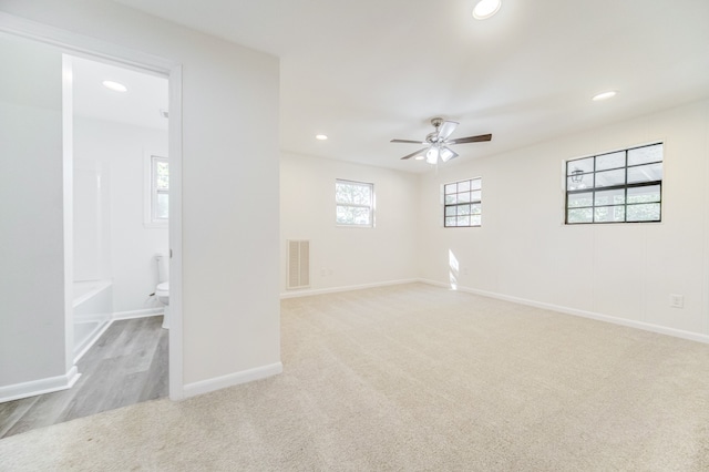 spare room with light colored carpet and ceiling fan