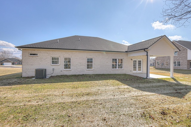 back of house with a yard and central AC