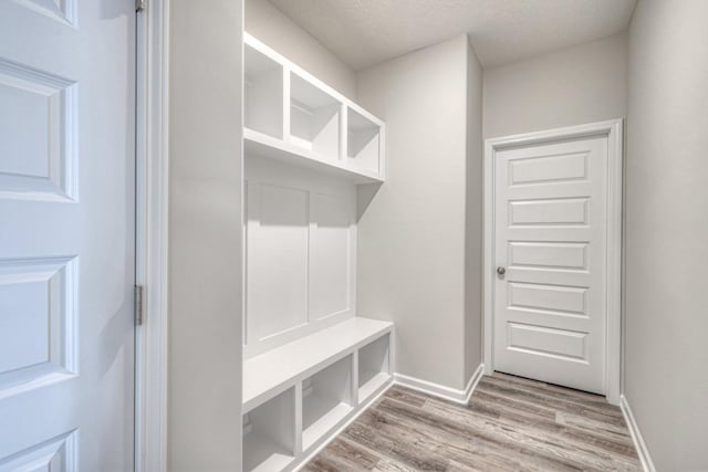 mudroom with light hardwood / wood-style floors and a textured ceiling