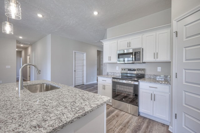 kitchen featuring stainless steel appliances, sink, white cabinets, and a textured ceiling