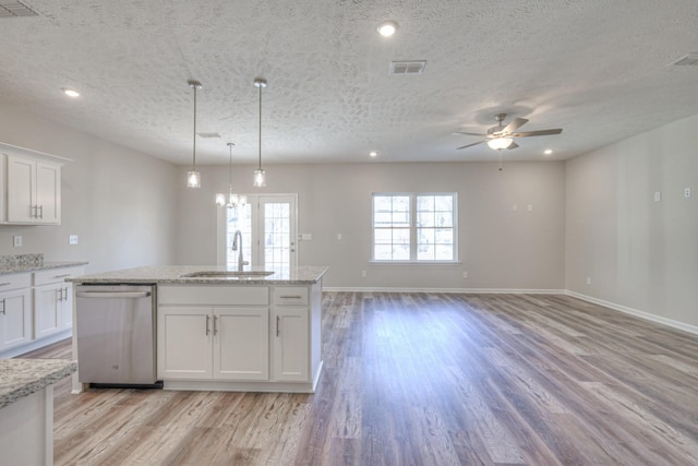 kitchen featuring decorative light fixtures, white cabinetry, dishwasher, sink, and light stone counters