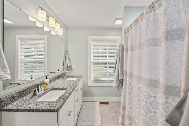 bathroom with a wealth of natural light, vanity, and tile patterned floors