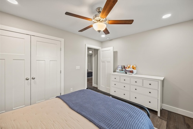 bedroom with dark hardwood / wood-style floors, a closet, and ceiling fan