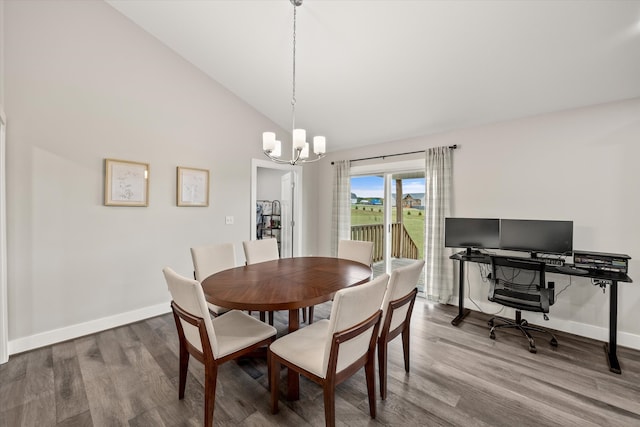 dining area featuring hardwood / wood-style flooring, a chandelier, and high vaulted ceiling