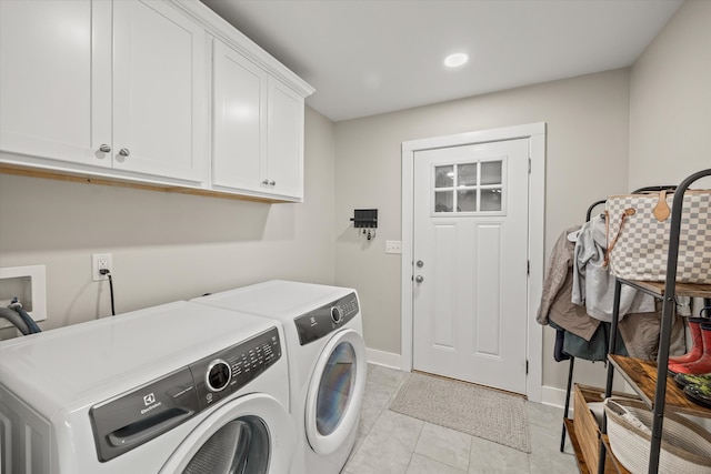 washroom featuring washing machine and clothes dryer, light tile patterned floors, and cabinets