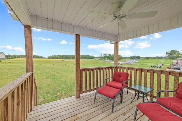 deck with a rural view, a yard, and ceiling fan