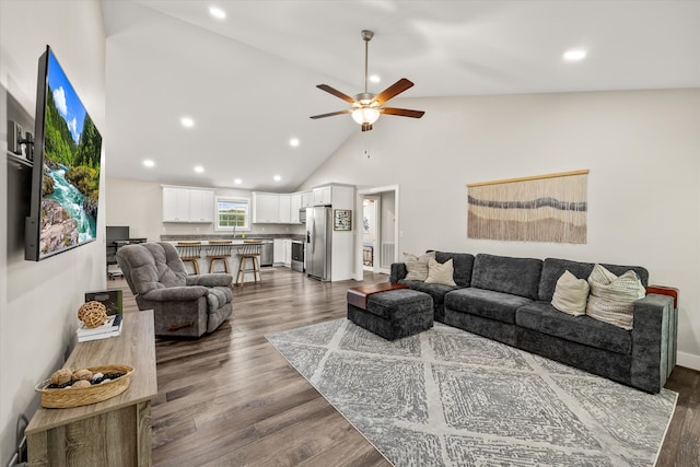 living room featuring dark hardwood / wood-style floors, high vaulted ceiling, and ceiling fan