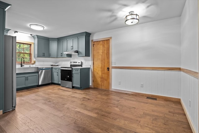 kitchen featuring sink, gray cabinetry, stainless steel appliances, and light hardwood / wood-style floors