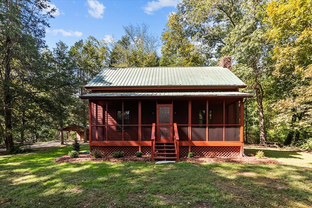 view of front of property featuring a front lawn and a sunroom