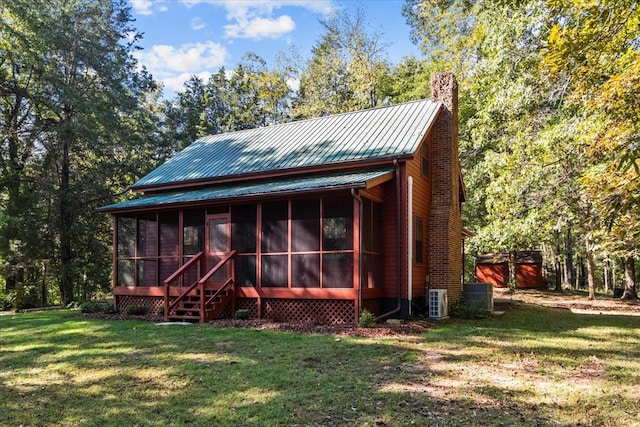 exterior space with a front yard, cooling unit, and a sunroom