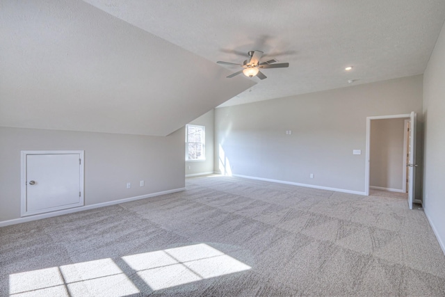 bonus room featuring ceiling fan, light colored carpet, lofted ceiling, and a textured ceiling