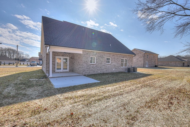 rear view of house with french doors, a yard, central AC unit, and a patio area