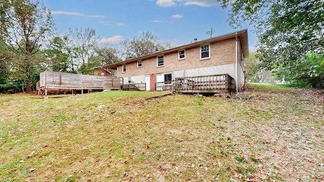 back of property with a deck and a yard