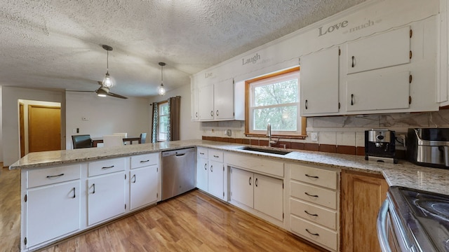 kitchen featuring kitchen peninsula, sink, pendant lighting, white cabinetry, and appliances with stainless steel finishes