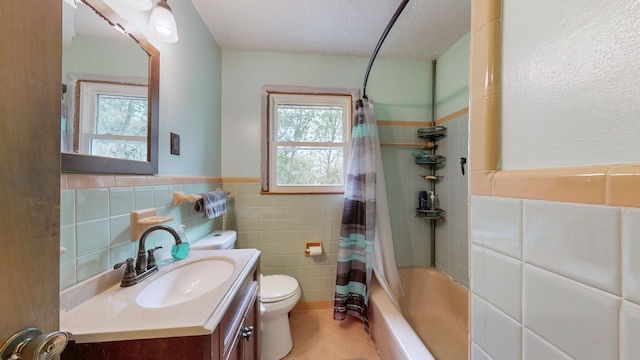 full bathroom with shower / tub combo, a textured ceiling, toilet, tile walls, and vanity