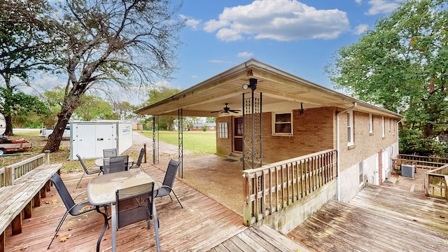 wooden deck with ceiling fan, a shed, and central AC unit