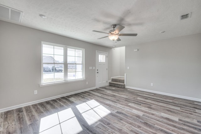 spare room with ceiling fan, a textured ceiling, and light wood-type flooring