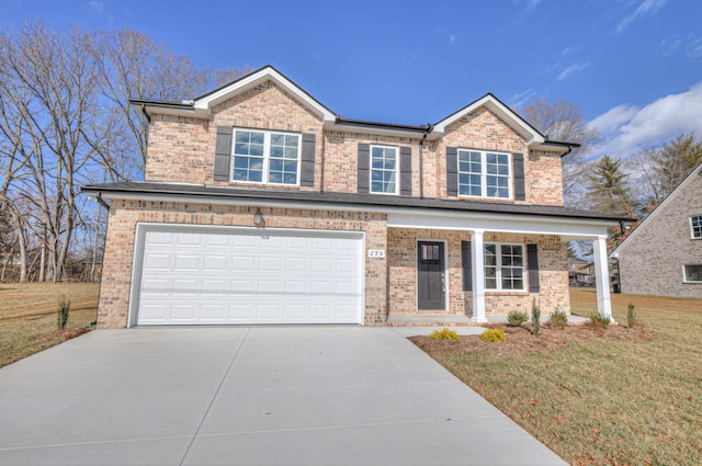 view of front of house featuring a garage, a front lawn, and covered porch