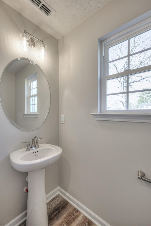 bathroom with wood-type flooring and a textured ceiling