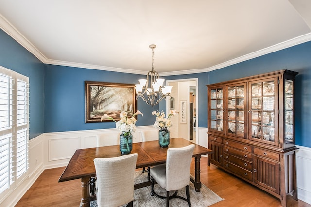 dining room featuring ornamental molding, a chandelier, and light hardwood / wood-style flooring