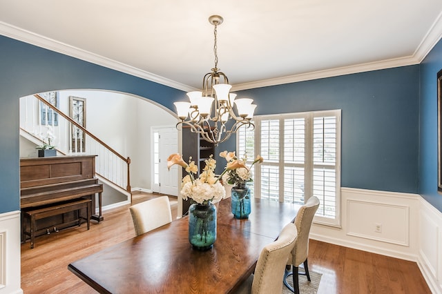 dining room featuring a notable chandelier, ornamental molding, and light hardwood / wood-style flooring