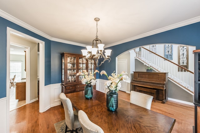 dining room featuring crown molding, hardwood / wood-style floors, and a notable chandelier