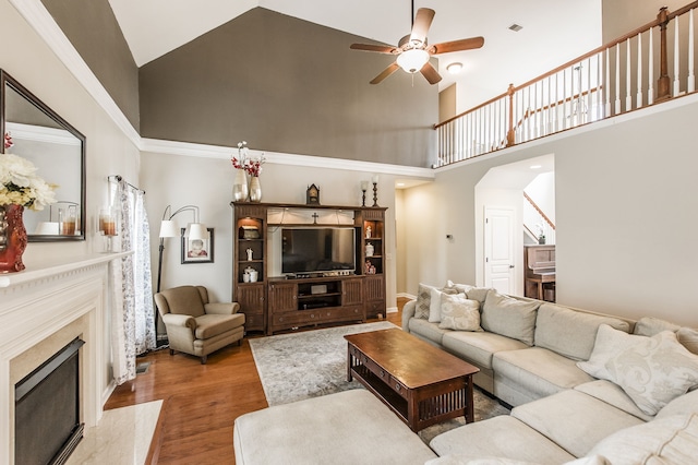 living room with ceiling fan, high vaulted ceiling, a fireplace, and hardwood / wood-style floors