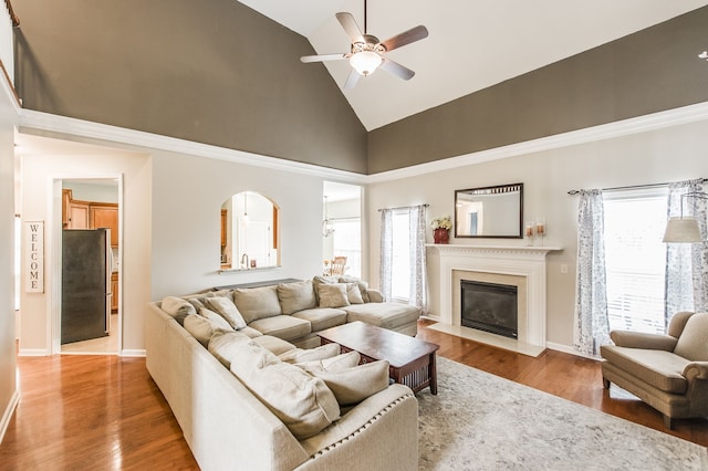 living room with hardwood / wood-style flooring, high vaulted ceiling, and ceiling fan