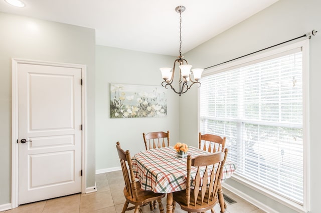 tiled dining room with an inviting chandelier