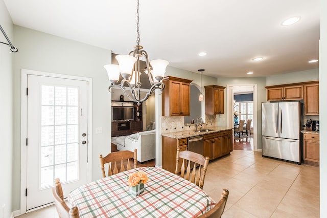 dining space with light tile patterned flooring, an inviting chandelier, and sink