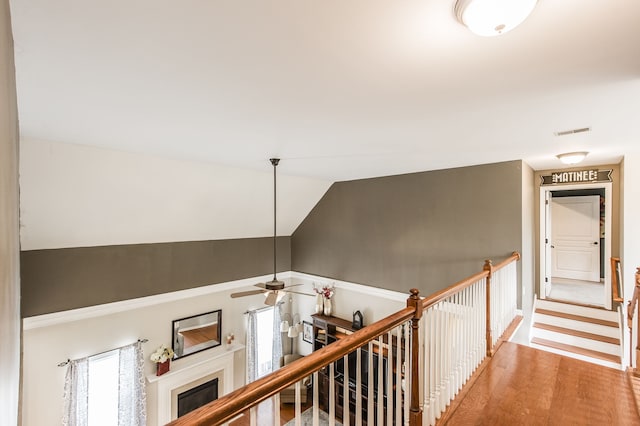 staircase featuring vaulted ceiling, hardwood / wood-style flooring, and ceiling fan