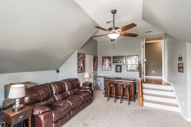 carpeted living room with ceiling fan and vaulted ceiling