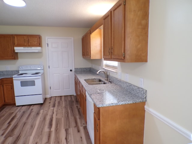 kitchen featuring sink, light hardwood / wood-style floors, a textured ceiling, and white appliances