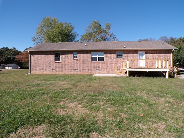 back of property with a deck and a lawn