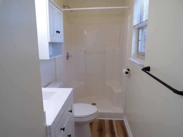 bathroom with vanity, hardwood / wood-style floors, toilet, and a shower