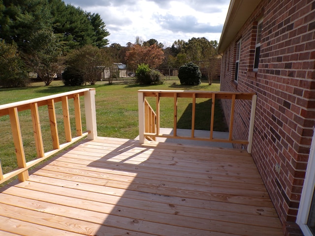 wooden terrace featuring a yard