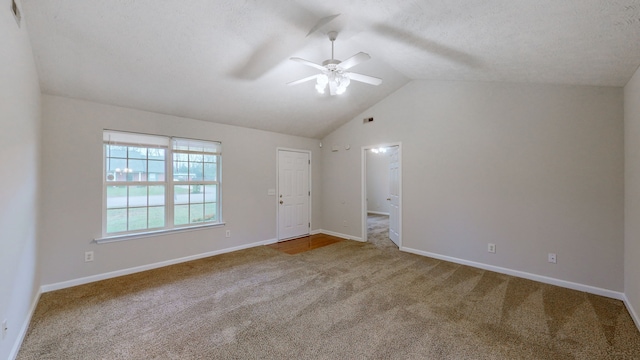 carpeted spare room with a textured ceiling, ceiling fan, and vaulted ceiling