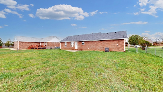 rear view of house with a lawn and a deck