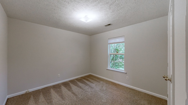 carpeted empty room featuring a textured ceiling