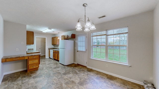 kitchen with a notable chandelier, plenty of natural light, pendant lighting, and white appliances