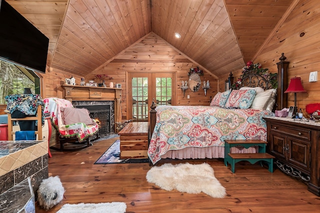 bedroom featuring lofted ceiling, a high end fireplace, hardwood / wood-style flooring, wooden ceiling, and wooden walls